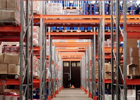 A modern warehouse interior showcasing organized shelves and pallets for efficient storage.