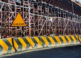 Construction site with a 'Slow Down' sign amid scaffolding in Kuwait.